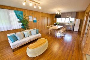 Una sala de estar con un sofá y una mesa y una cocina. en 稲嶺貸家,  39 fotos más