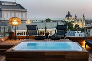 
a hotel room with a balcony overlooking the ocean at Palacio de los Duques Gran Meliá - The Leading Hotels of the World in Madrid
