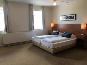 twee bedden in een kamer met twee ramen bij Welcome Apartments in Ólafsvík