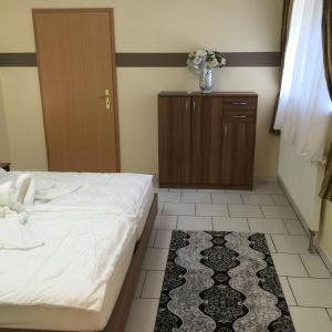 ein Schlafzimmer mit einem Bett, einem Schrank und einem Teppich in der Unterkunft Boulevard Apartment in Raunheim
