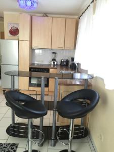 a kitchen with two black bar stools and a counter at Boulevard Apartment in Raunheim +15 photos