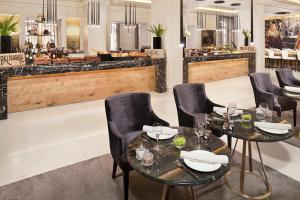 a restaurant with two tables and chairs and a bar at Palacio de los Duques Gran Meliá - The Leading Hotels of the World in Madrid