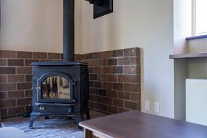 a wood stove in a room with a table at Niseko Mt Village in Niseko +121 photos