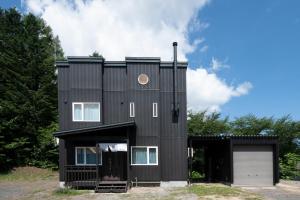 a black house with a garage at Niseko Mt Village in Niseko