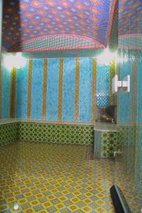 a bathroom with a shower with a colorful tiled wall at HON SAROY - immerse atmosphere in the epoch of the khans in Tashkent