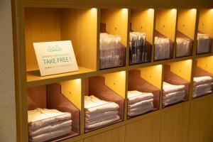 uno scaffale pieno di asciugamani con un cartello che dice "prendili gratis" di Prince Smart Inn Hakata a Fukuoka