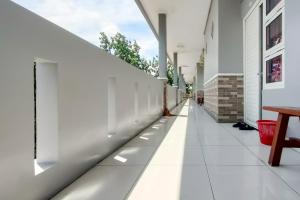 un couloir vide d'un immeuble aux murs blancs dans l'établissement RedDoorz at NN Guest House Exit Tol Klodran Solo, à Solo