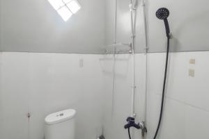 une douche avec pommeau de douche dans une salle de bain dans l'établissement RedDoorz at NN Guest House Exit Tol Klodran Solo, à Solo