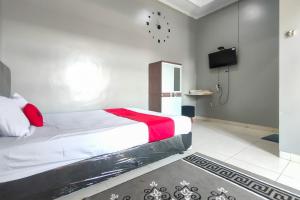 une chambre avec un lit et une télévision dans l'établissement RedDoorz at NN Guest House Exit Tol Klodran Solo, à Solo 18 autres photos