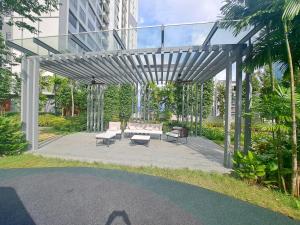 a pergola with a couch and chairs on a patio at Agile universal service residence TRX KL in Kuala Lumpur