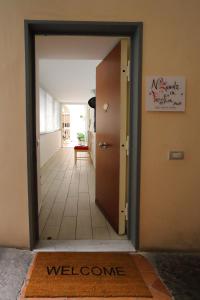 una puerta que conduce a un pasillo con una alfombra de bienvenida en Napoli a Festa, en Nápoles