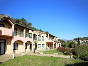 a row of pink buildings with a yard at B&B HOTEL Villeneuve Loubet Village in Villeneuve-Loubet