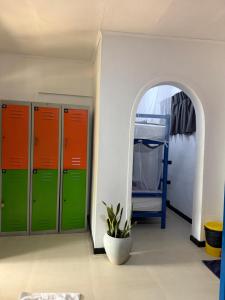 a locker room with green and orange lockers and a mirror at Hive Ella - Hostel in Ella