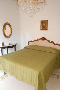 アルチドッソにあるAffittacamere Le Fontiのベッドルーム(緑のベッド1台、鏡付)