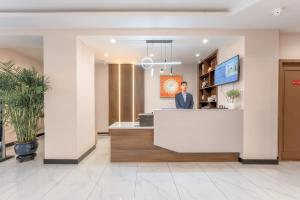 Een man bij een receptie in een lobby. bij Zhongmai Yunting Hotel in Harbin