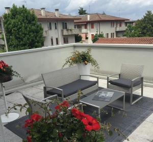 a patio with two chairs and a table and flowers at Hotel Vittoria in Rubano