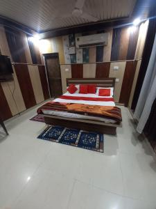 a bedroom with a large bed with red pillows at Suryakulam palace in Ayodhya