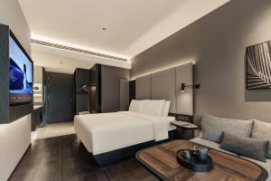 a hotel room with a bed and a couch at Atour Hotel, Wending Road, Xujiahui Center, Shanghai in Shanghai