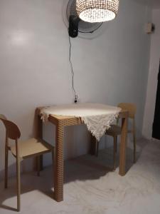 a table and chairs with a table and a fan at Silid Siargao in General Luna