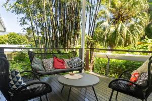 un porche con 2 sillas y una mesa en el balcón en Urban Jungle Townhouse - Tropical Living, en Edge Hill