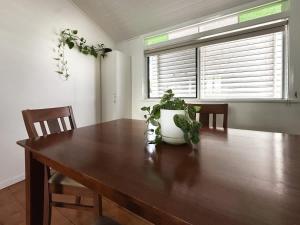 a dining room table with a potted plant on it at Classic City Queenslander - Walk to Esplanade in Cairns North
