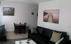 a living room with a black couch and a table at Paris Stade de France in Saint-Denis