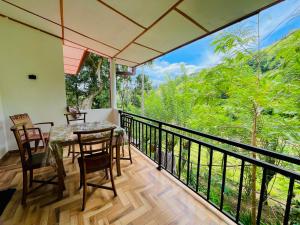 a dining room with a table and chairs on a balcony at New Forest Glen Nest in Ella