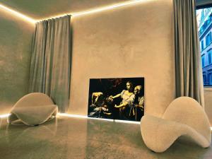 a room with two chairs and a picture on the wall at DUNE at Spanish Steps Luxury Apartment-Suite in Rome