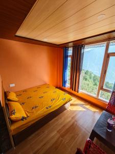 a bedroom with a bed with a yellow comforter at The District Green in Kalpa