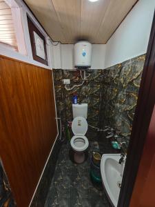 a small bathroom with a toilet and a sink at The District Green in Kalpa +54 photos