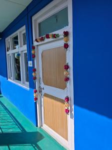 a front door of a house with flowers on it at The District Green in Kalpa