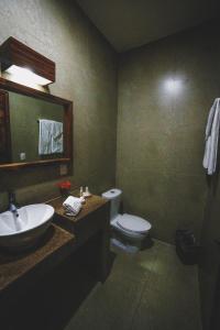 a bathroom with a sink and a toilet and a mirror at Hotel San Pablo in Colima