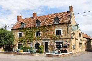 an old stone building with ivy on it at The Hare and Hounds in Fulbeck