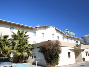 a building with a car parked in front of it at B&B HOTEL Villeneuve Loubet Plage in Villeneuve-Loubet