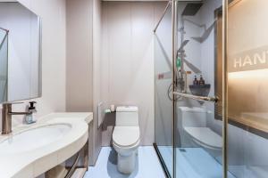 een badkamer met toilet, wastafel en douche bij Zhongmai Yunting Hotel in Harbin +25 foto's