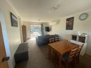 a living room with a table and a couch at Mountain Views Cedar Cottage in Blackheath