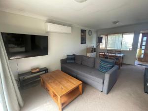 una sala de estar con un sofá y una mesa en Mountain Views Cedar Cottage, en Blackheath