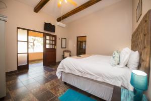 a bedroom with a large white bed in a room at Foreva Wild in Klipdrift