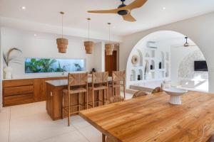 a dining room and kitchen with a wooden table and chairs at Stylish 3BR Villa - Walk to Pererenan Beach in Pererenan
