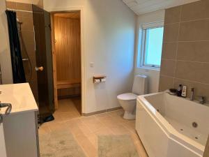 a bathroom with a tub and a toilet and a sink at Explore Bay And Nature In Pretty Kostræde Banker in Køng +32 photos