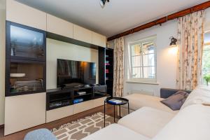 a living room with a white couch and a flat screen tv at Anties Namai in Juodkrantė