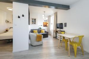 a living room with a couch and a table at Breuil Station, studio tout confort in La Mure +2 photos