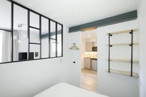 a room with white walls and a large mirror on the wall at Breuil Station, studio tout confort in La Mure