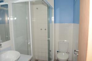 a bathroom with a toilet and a glass shower at Pousada Ilha Maravilha in Rio de Janeiro