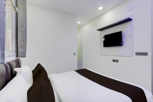 a bedroom with a white bed and a window at Hotel O Rohini Sector 21 Shelter Inn in New Delhi +17 photos