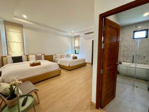 Cette chambre comprend deux lits et une baignoire. dans l'établissement Montere Hus Pool Villa Khao Yai, à Wangkata 18 autres photos