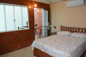 a bedroom with a bed and a brick wall at Pousada Ilha Maravilha in Rio de Janeiro