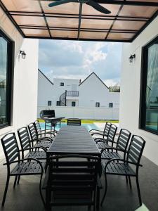un patio avec une table et des chaises et une piscine dans l'établissement Montere Hus Pool Villa Khao Yai, à Wangkata