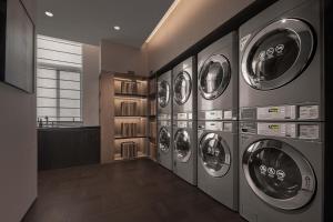 a row of washers and dryers in a laundry room at Atour Hotel, Wending Road, Xujiahui Center, Shanghai in Shanghai