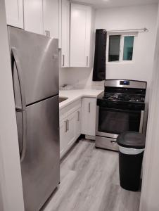 a kitchen with a stainless steel refrigerator and white cabinets at La Cienega Soul in Los Angeles